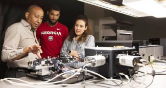 From left, professor Yohannes Abate talks with graduate students Marquez Howard and Neda Aghamiri about equipment used for nanoscale imaging and spectroscopy in his lab. (Photo taken by Andrew Davis Tucker/UGA prior to March 2020.)